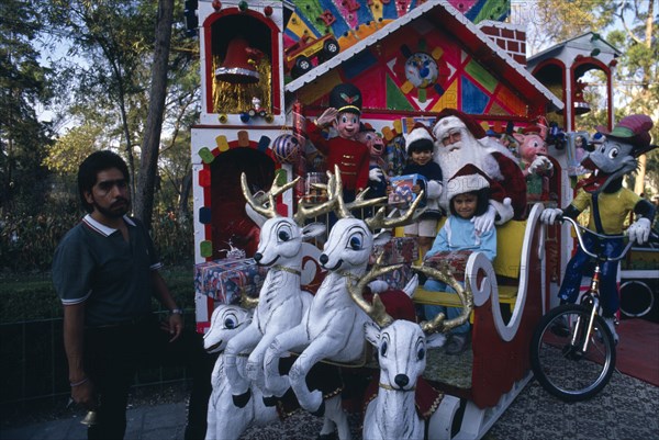 MEXICO, Mexico City, Children visiting Father Christmas in his sleigh in Mexico City Park