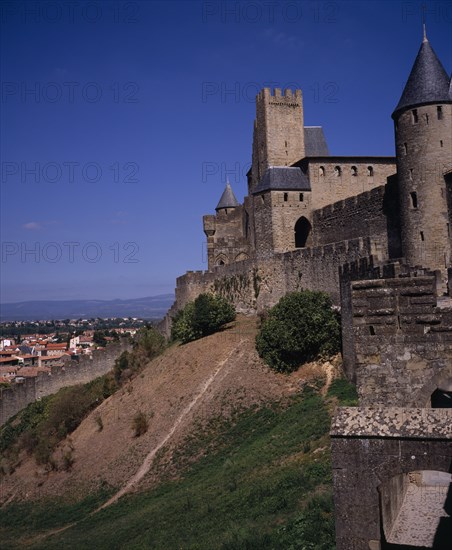 FRANCE, Languedoc-Roussillon, Aude, Carcassonne.  Gateway in medieval fortified outer walls of town with the Counts Chateau behind.