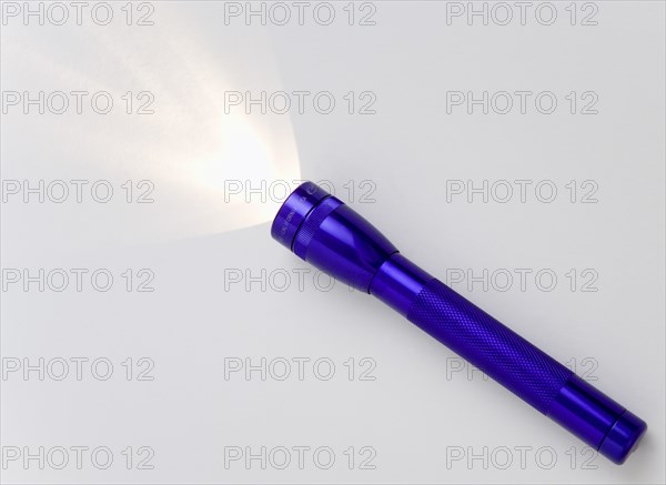 TOOLS, Household, Torch, Purple magilite torch turned on and casting a beam of light over a white surface
