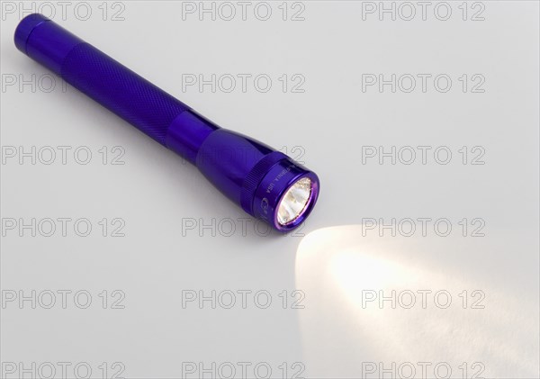 TOOLS, Household, Torch, Purple magilite torch turned on and casting a beam of light over a white surface