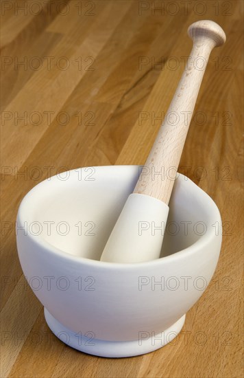 HOUSEHOLD, Kitchenware, Cooking, White ceramic pestle and mortar on a wooden kitchen surafce worktop