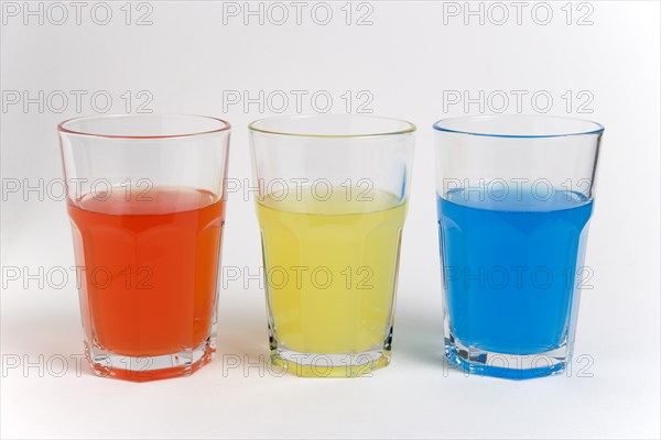 DRINK, Soft Drinks, Sugar, "Soda glasses containing light red, yellow and blue coloured soft drinks"