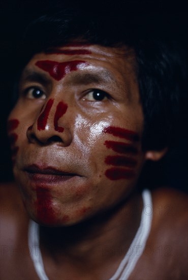 COLOMBIA, North West Amazon, Tukano Indigenous Tribe,  Portrait of Venancio Makuna (sub-group of Tukano) headman Ignacio's son  decorated with red Achiote facial paint for dance/manioc ceremony