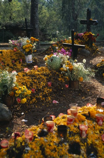 MEXICO, Michoacan, Patzcuaro, "Tzurumutaro Cemetery.  Graves decorated with candles, carved pumpkins and marigold flowers for the Day of the Dead."