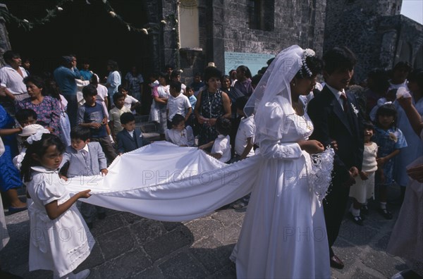 MEXICO, Misquic, "Wedding party outside church with bride and groom, bridesmaid and page boy in foreground."