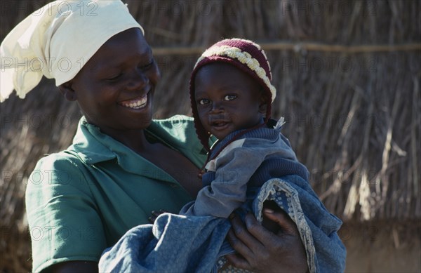 20088800 MOZAMBIQUE  People Portrait of laughing young woman carrying child  refugees repatriated from Zimbabwe through the UNHCR  the UN High Commissioner for Refugees.