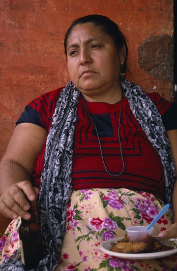 MEXICO, Oaxaca, Juchitan, Matriarchal society.  Portrait of seated women holding bottle and plate of food.