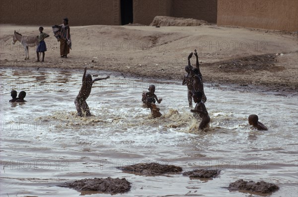20088881 NIGER  Agadez Tuareg children playing in rain pool.