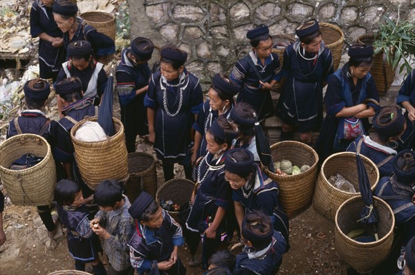 20088979 VIETNAM North Sapa Muong tribes people carrying woven panniers at market.