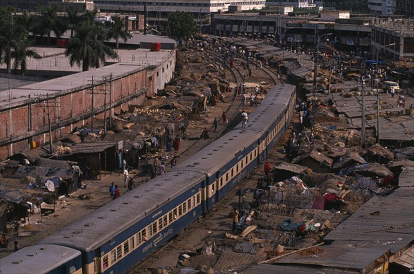 BANGLADESH, Dhaka, Tejgaon, Train passing through overcrowded slum housing lining the railway track.