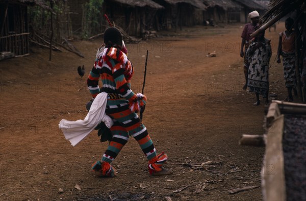 CAMEROON, South West, Rumpi Hills, Masked Ju-ju man wearing striped costume taking part in Leopard Cult or Ekpe masquerade in rainforest village near Mundemba.