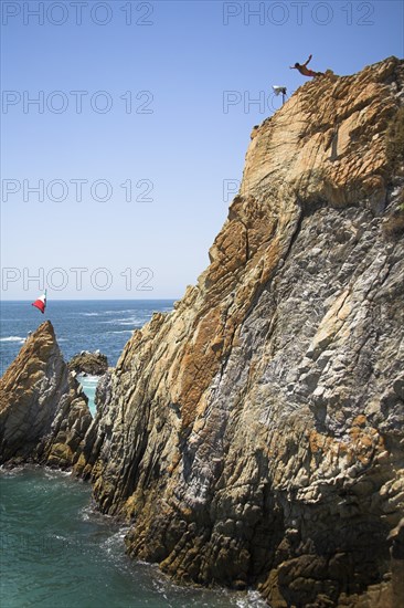 MEXICO, Guerrero State, Acapulco, "Cliff diver, a clavadista, diving off the cliffs at La Quebrada"