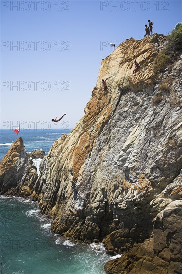 MEXICO, Guerrero State, Acapulco, "Cliff diver, a clavadista, diving off the cliffs at La Quebrada"