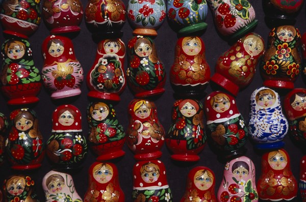 HUNGARY, Budapest, Colourful painted matryoshka dolls for sale in souvenir shop.  Displayed in lines against dark backgound.