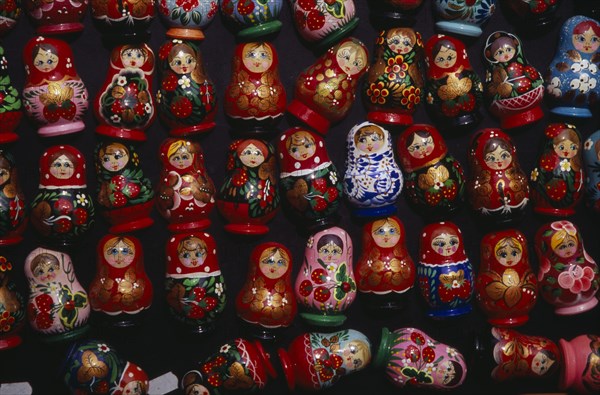HUNGARY, Budapest, Colourful painted matryoshka dolls for sale in souvenir shop.  Displayed in lines against dark backgound.