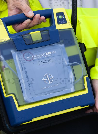 ENGLAND, West Sussex, Findon, Sheep Fair Ambulance service driver holding a mobile emergency fibulator