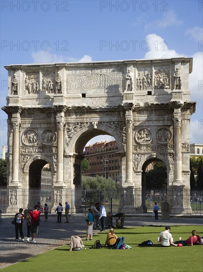 ITALY, Lazio, Rome, Tourists at the base of the 3rd century Arch of Constantine outside the Forum beside the Colosseum commemorating his victory over his co-emperor Maxentius
