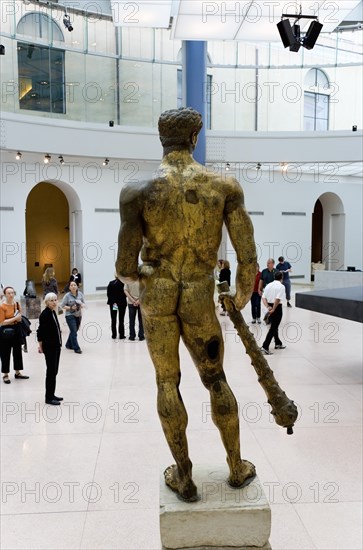 ITALY, Lazio, Rome, The Capitoline Museum palazzo dei Conservatori. Visitors view the 2nd Century BC gilded bronze statue of Hercules in the Portico of Marcus Aurelius