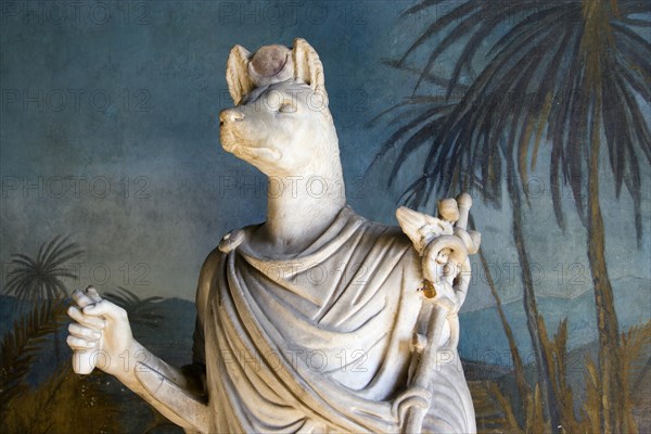 ITALY, Lazio, Rome, "Vatican City Museum Part of the reconstruction of Hadrian's Villa (Tivoli) showing the 2nd Century white marble Statue of the god Anubis, lord of mummification, who guided the dead to the underworld, here represented according to the Roman style as a personage clad in a toga, but following an ""Egyptian"" iconography. In his right hand he holds a sistrum, while in the left he has the caduceus of Hermes, which was used to guide the souls in the Greek-Roman religion"