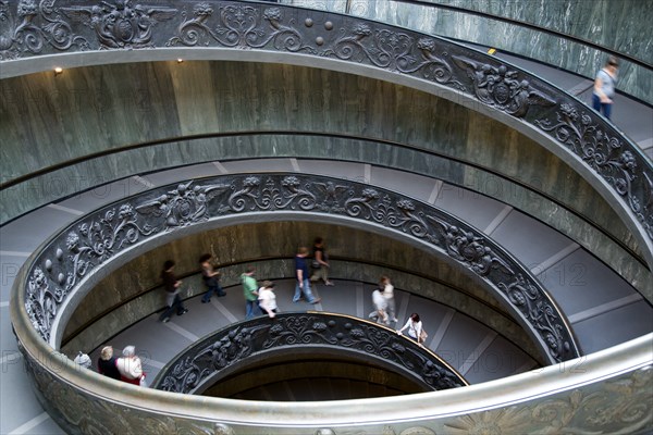 ITALY, Lazio, Rome, Vatican City People descending the spiral ramp from the Museum to the street designed in 1932 by Guiseppe Momo