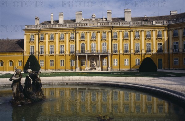 HUNGARY, Burgenland, Eisenstadt , Schloss Esterhazy Palace yellow painted exterior seen from across a water fountain