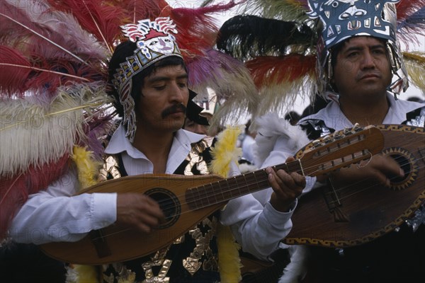MEXICO, Mexico City, Musicians wearing elaborate feather head-dresses and costumes during Festival of Our Lady of Guadaloupe