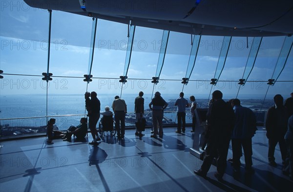 ENGLAND, Hampshire, Portsmouth, "Gunwharf Quays. The Spinnaker Tower. Interior at top of tower with visitors looking out glass windows on the observation deck providing a 320° view of the city of Portsmouth, the Langstone and Portsmouth harbours, and a viewing distance of 37 kilometres (23 miles"