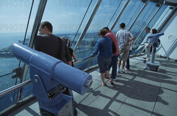 ENGLAND, Hampshire, Portsmouth, "Gunwharf Quays. The Spinnaker Tower. Interior at top of tower on the observation deck with visitors looking out of glass windows providing a 320° view of the city of Portsmouth, the Langstone and Portsmouth harbours, and a viewing distance of 37 kilometres (23 miles"