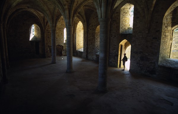 ENGLAND, East Sussex, Battle, Battle Abbey. The novice's room with a lone man seen standing under a doorway
