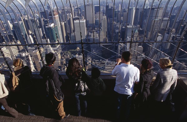 USA, New York, New York City, View north over city  from top of the Empire State Building at 8.30 a.m. with line of visitors looking out through expanse of glass.
