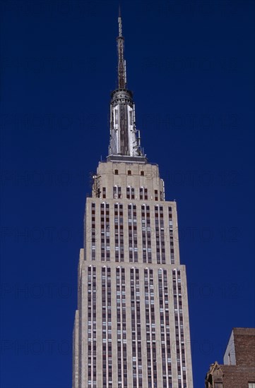 USA, New York, New York City, "Part view of the Empire State Building from East 34th Street.  Art Deco, steel framed building with radio and TV mast completed in 1931.   Designed by architect William Lamb of Shreve, Lamb and Harmon Associates."