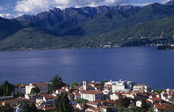 ITALY, Piedmont, Lake Maggiore, Stresa.  View over red tiled rooftops of town towards lake and mountain backdrop from Monte Mottarone.