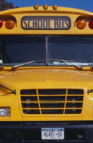 USA, New York, New York City, "Cropped shot of bright yellow front bumper, windscreen and number plate of school bus."