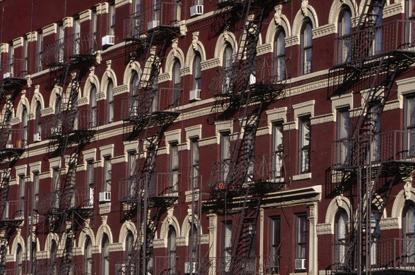 USA, New York, New York City, "Greenwich Village.  Houses on 7th Avenue, red brick exteriors with cream coloured architectural detail and decorative metal fire escapes."