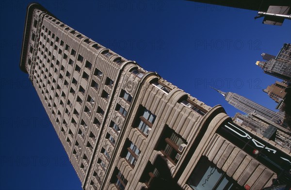 USA, New York, New York City, "Angled view of the Flatiron Building from 23rd Street.  Steel framed, Beaux-Arts skyscraper designed by architect Daniel Burnham in 1902 to a triangular plan. "