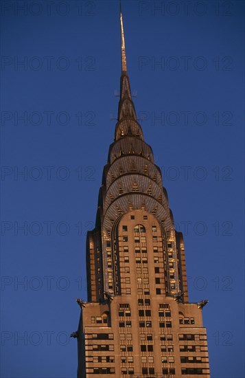 USA, New York, New York City, Part view of the Chrysler Building from East 42nd Street lit by golden light.  Steel framed Art Deco skyscraper built 1928-1930 and designed by architect William Van Alen.