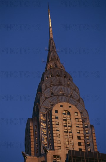 USA, New York, New York City, Part view of the Chrysler Building from East 42nd Street lit by golden light.  Steel framed Art Deco skyscraper built 1928-1930 and designed by architect William Van Alen.