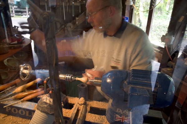 ENGLAND, West Sussex, Amberley, Amberley Working Museum. The West Sussex Woodturners with a man working at Machinery  demonstrating traditional wood-working tools and skills