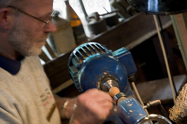 ENGLAND, West Sussex, Amberley, Amberley Working Museum. The West Sussex Woodturners with a man working at Machinery  demonstrating traditional wood-working tools and skills