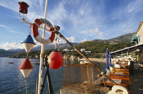 MONTENEGRO, Przno, Waterfront restaurants with fishing nets and nautical decoration looking out towards the sea