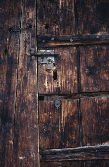 FRANCE, Architectural Detail, "Detail of wooden door of old French farmhouse with bolt, padlock and chain and original keyhole."