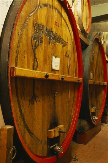 ITALY, Veneto, Lake Garda, Bardolino.  Large wooden wine casks in cellar at the Museum of Wine.  Barrel in foreground labelled as containing Valpolicella.