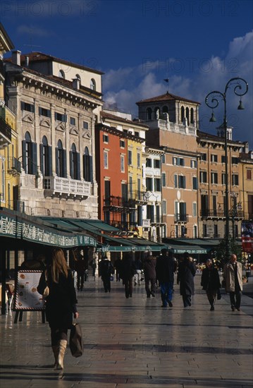ITALY, Veneto, Verona, Piazza Bra.  People walking past line of bars and cafes and painted facades of architecture overlooking square.
