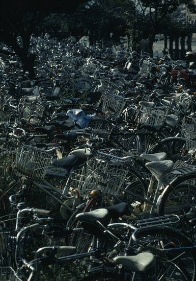 JAPAN, Honshu, Kyoto, Mass of commuter’s bicycles parked beside a station.