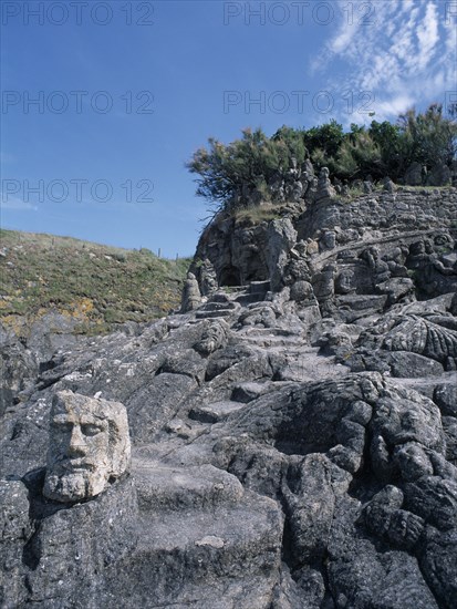 FRANCE, Brittany, St Malo, Rochers Sculptes de Rotheneuf. Sculptures of faces carved into rock