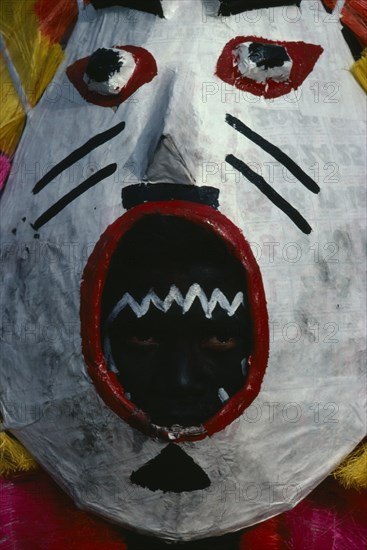 PHILIPPINES, Panay Island, Kalibo, Portrait of dancer looking out through mouthpiece of carnival mask during Ati-Atihan festival and feast in honour of Santo Nino (Holy Child).