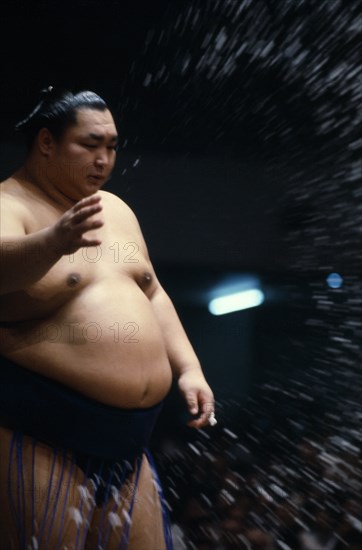 JAPAN, Samurai, Sumo, Sumo wrestler throwing handfuls of salt into the ring as an act of purification.  Sumo has close asociations with the Shinto religion with fights taking place beneath a symbolic Shinto-style roof.