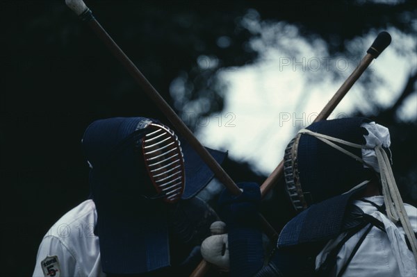 JAPAN, Samurai, Kendo, Two opponents in bogu armour facing each other over crossed shinai bamboo swords.  The Samurai art of kenjutsu was transformed into the sport of kendo using swords of bamboo and protective face guards.