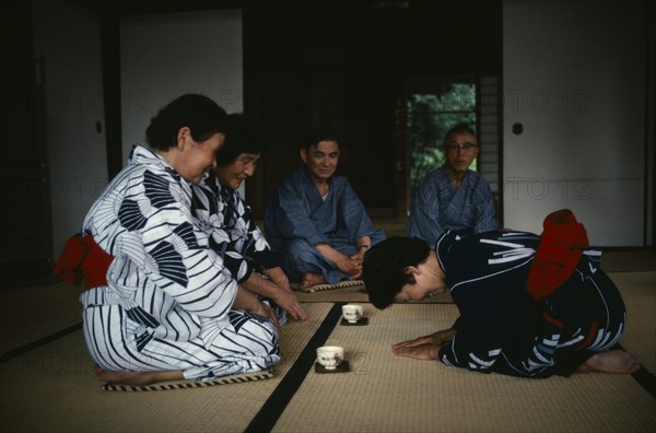 JAPAN, Samurai, Custom, "The samurai class no longer exists, but there are still samurai families who remain proud of their ancestry and who continue to live in traditional samurai houses.  Women dressed in kimonos kneel on floor and give low bow with tea bowls placed on floor in front of them. "
