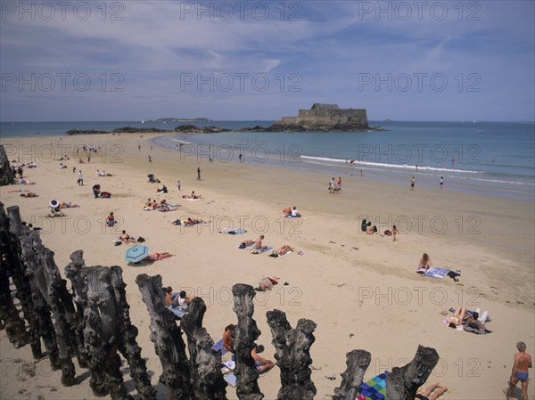 FRANCE, Brittany, St Malo, Le Sillon Beach and Fort National. Sunbathers on golden sand